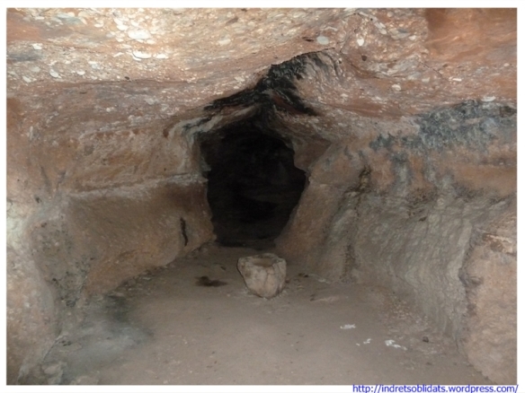 Primer tram de la cova de la Cort Fosca. Cal observar la curiosa pica de pedra (la foto és feta amb flash, la foscor és absoluta)